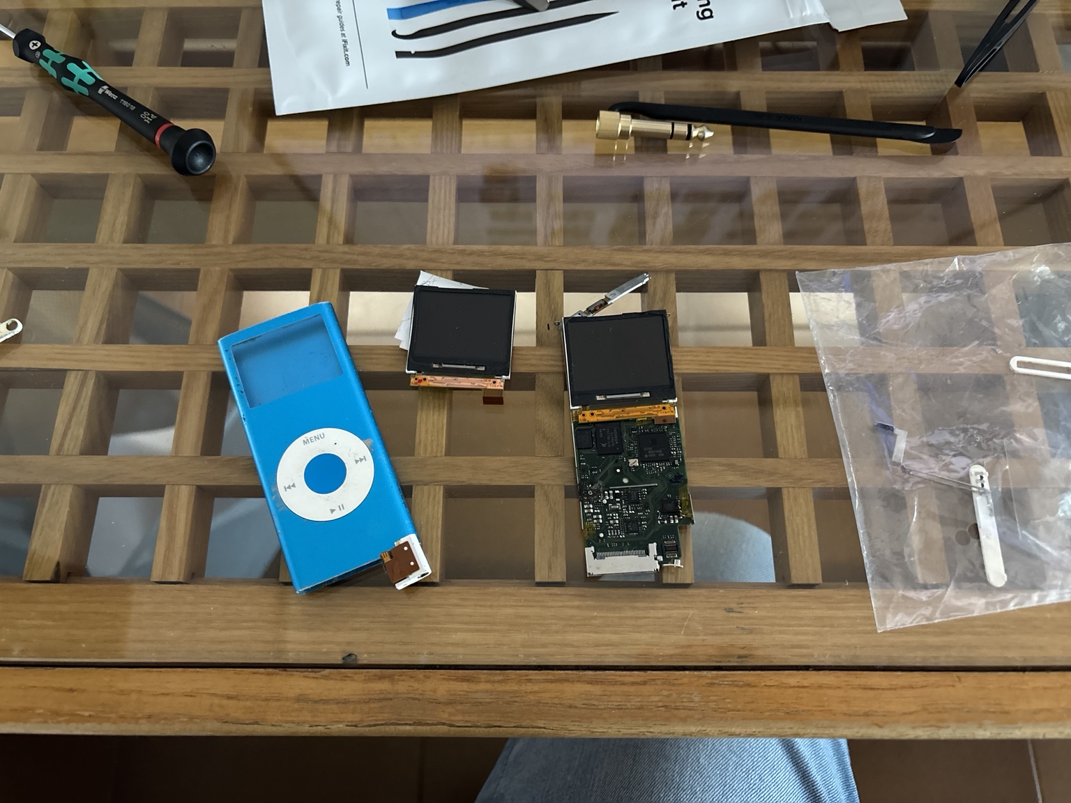 L'iPod donatore smontato, con il guscio blu e i due display sul tavolo